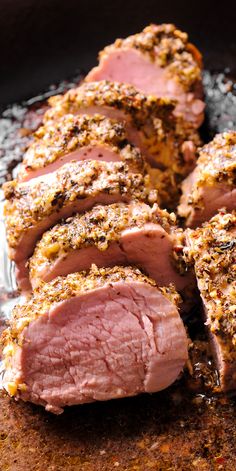 sliced meat sitting on top of a pan covered in seasoning