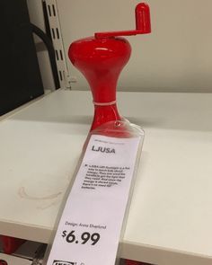 a red object with a price tag on it sitting on top of a white table