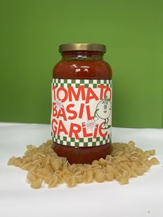 a jar of tomato basil garlic sauce sitting on top of some uncooked pasta