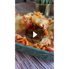 a green casserole dish filled with lasagna shells and meat sauces