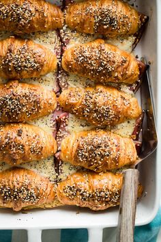 a baking dish filled with rolls covered in cheese and sesame seeds