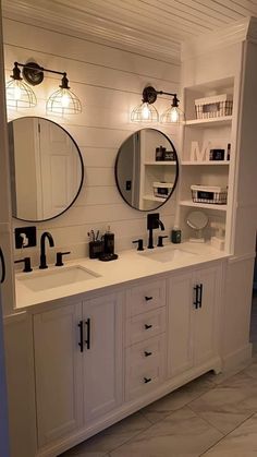 a bathroom with double sinks and two mirrors on the wall next to eachother