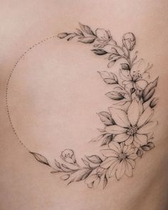 the back of a woman's stomach with flowers and leaves on it, as well as an arrow