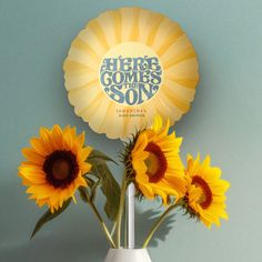 three sunflowers in a white vase with an ad for the song'here comes my son '