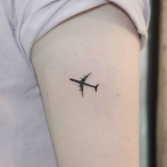 a small airplane tattoo on the left upper half of the right arm, it is black and white