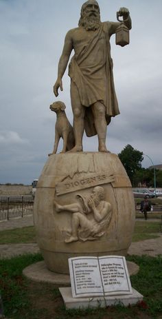 a statue of a man with a dog on top of a ball in the grass