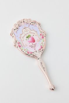 a pink and white brooch with strawberries on it's side, in the shape of a tennis racket