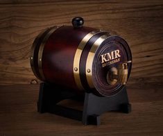 an old fashioned wooden barrel on a stand with the word kmr written on it