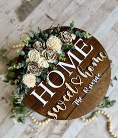 a wooden sign with flowers and greenery on it that says home sweet & savor