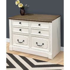 a white dresser with drawers and flowers on top