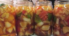 jars filled with pickled vegetables sitting on top of a counter next to each other