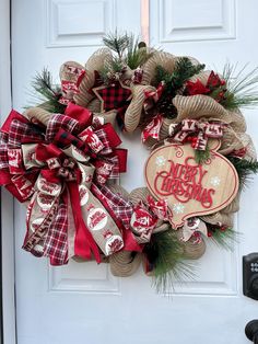 a christmas wreath is hung on the front door with burlocks and pine cones