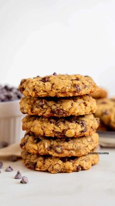 chocolate chip oatmeal cookies stacked on top of each other in front of a bowl