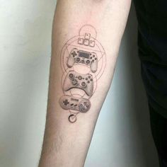 a person with a tattoo on their arm holding a video game controller