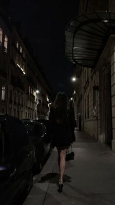 a woman walking down the street at night