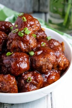 cranberry meatballs in a white bowl with green onions