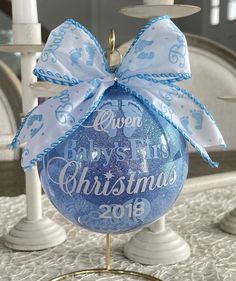 a baby's first christmas ornament hanging from a candle holder on a table