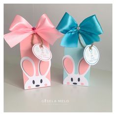 two small boxes with pink and blue bows on them, one has a bunny face