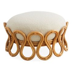 a stool made out of wicker with white cushions on it's back end