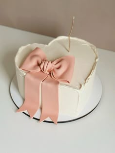 a heart shaped cake with pink bows on top