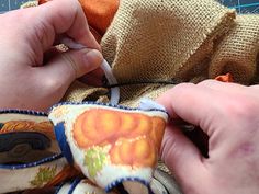 someone is working on something with fabric and scissors in their hands, while they are sewing