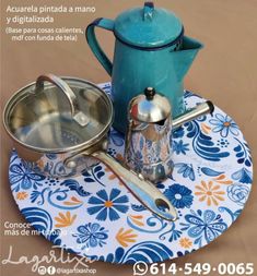 a tea pot and saucer on a plate with a flowered place mat in front of it