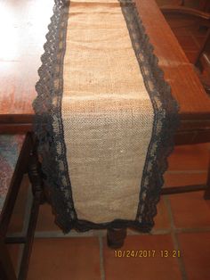 the table is covered with a black lace and burlocked runner on it