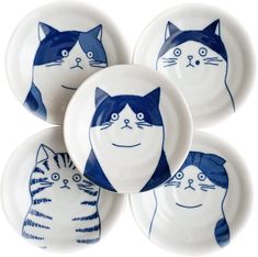 four blue and white plates with cats painted on them