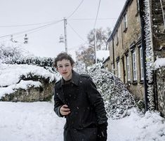 a young man is walking in the snow