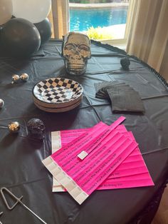 the table is set up with pink napkins and other items on it, including a skull head