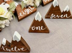 wooden mountain name tags on a table with flowers