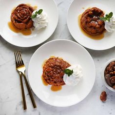 three white plates topped with desserts on top of a marble counter next to silverware