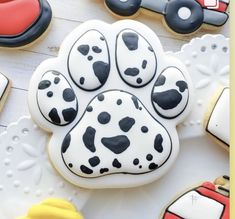 decorated cookies with dog's paw and cars in the shape of hearts on a table