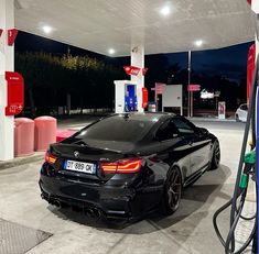 a black car is parked at a gas station