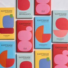 six different colored chocolate bars on a white tablecloth with the words gotham written below them