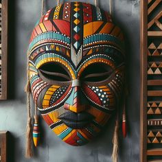 a colorful mask is hanging on the wall