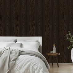 a white bed sitting next to a wooden wall