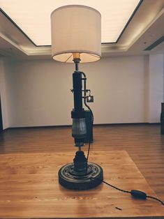 a lamp that is on top of a wooden table in a room with hard wood flooring