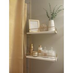 two shelves with items on top of each other in a bathroom next to a shower curtain