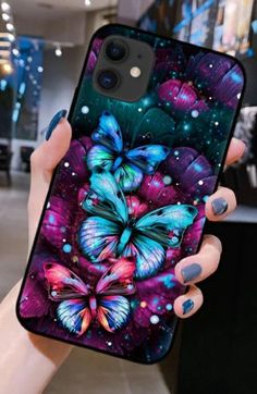 a woman's hand holding up a phone case with colorful butterflies on the cover