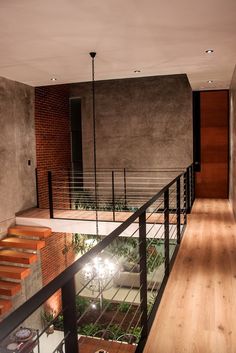 an empty room with stairs and lights in the center, next to a brick wall