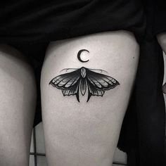 a woman's thigh with a moth tattoo on her lower leg and the moon behind it