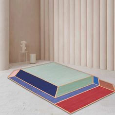 a multicolored rug on the floor in front of a wall with vertical blinds