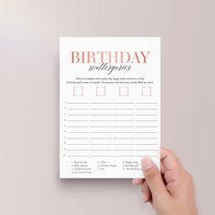 a hand holding up a birthday wish list