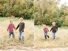 two young boys holding hands and walking through tall grass