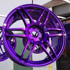 purple rims are hanging from the side of a building