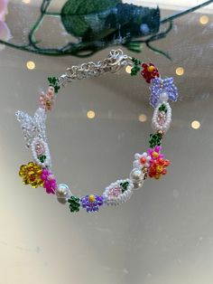 This beautiful  multi color flowers bracelet is handmade. Would be a great gift for her, a wedding gift, Christmas gift, and more, z You can make them into matching bridesmaid, bracelets, party favors, and just an every day accessory. If you would like I can customize any colors on the bracelet just send me a message. I offer lengths 5 inches to 9 inches. If you need another size, please let me know and I would love to make it for you. If you do not like the clasp I have other options just let me know when I can send you some pictures. This product is fully customizable at no additional cost. If you have any questions about this item, please let me know and feel free to message me. Whimsical White Beaded Bracelets As A Gift, Whimsical White Beaded Bracelets As Gift, White Whimsical Beaded Bracelet As Gift, Whimsical White Beaded Bracelet As Gift, Dainty Multicolor Flower Jewelry, Beaded Bracelets With Flower Charm For Gift, White Beaded Bracelets With Tiny Beads For Party, Spring Beaded Bracelet For Parties, Elegant Multicolor Flower Beaded Bracelets