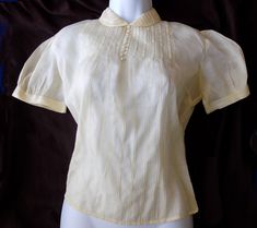 Mint condition rare and early Patty Woodard of California sheer cotton blouse, in a pale, pastel yellow. NO FLAWS! Several buttons were missing, and I had buttons that matched perfectly in my vintage button collection, to match the three lower ones missing in front. For the back I had 2 that were close enough in size and shape and material, to replace the two that were missing. See close ups. Label is sewn in sideways, not right side up. This is a small label measuring 1.25" long. I recently got this at an estate sale. All I had to do was press it and add the buttons. I thought this was from the 40s, due to the use of real pearl buttons, but the only on-line info I have so far is that she started in the early 50s. Another seller on Etsy has a similar one for sale at $120. Go by measurement Men Vintage Fashion, Yellow Blouse, Pastel Yellow, Cotton Blouse, Vintage Button, Pan Collar, Peter Pan Collar, Cotton Blouses, Peter Pan