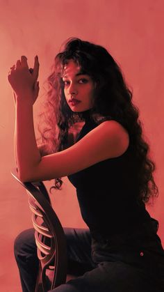 a woman with long hair sitting on a chair