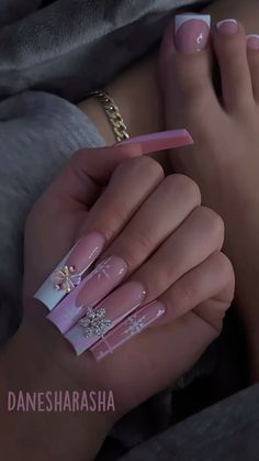 a woman's feet with pink and white nail polish on them, while she is laying down